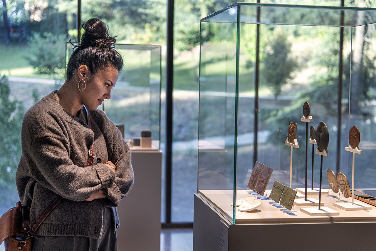 Una visitante en la muestra “Monumentos de bolsillo. Francisco López Hernández y el Arte de la Medalla de la Complutense”