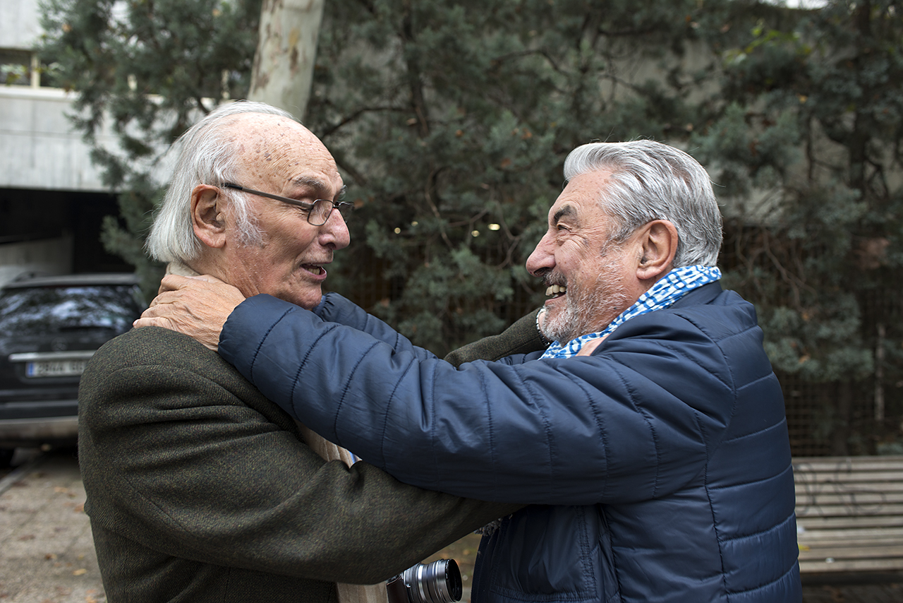 Carlos Saura saluda al fotógrafo César Lucas frente a la Facultad de Ciencias de la Información en el año 2016