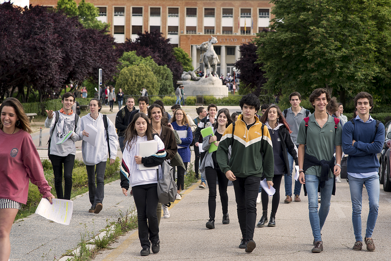 Estudiantes caminando ante la escultura "Los portadores de la Antorcha"