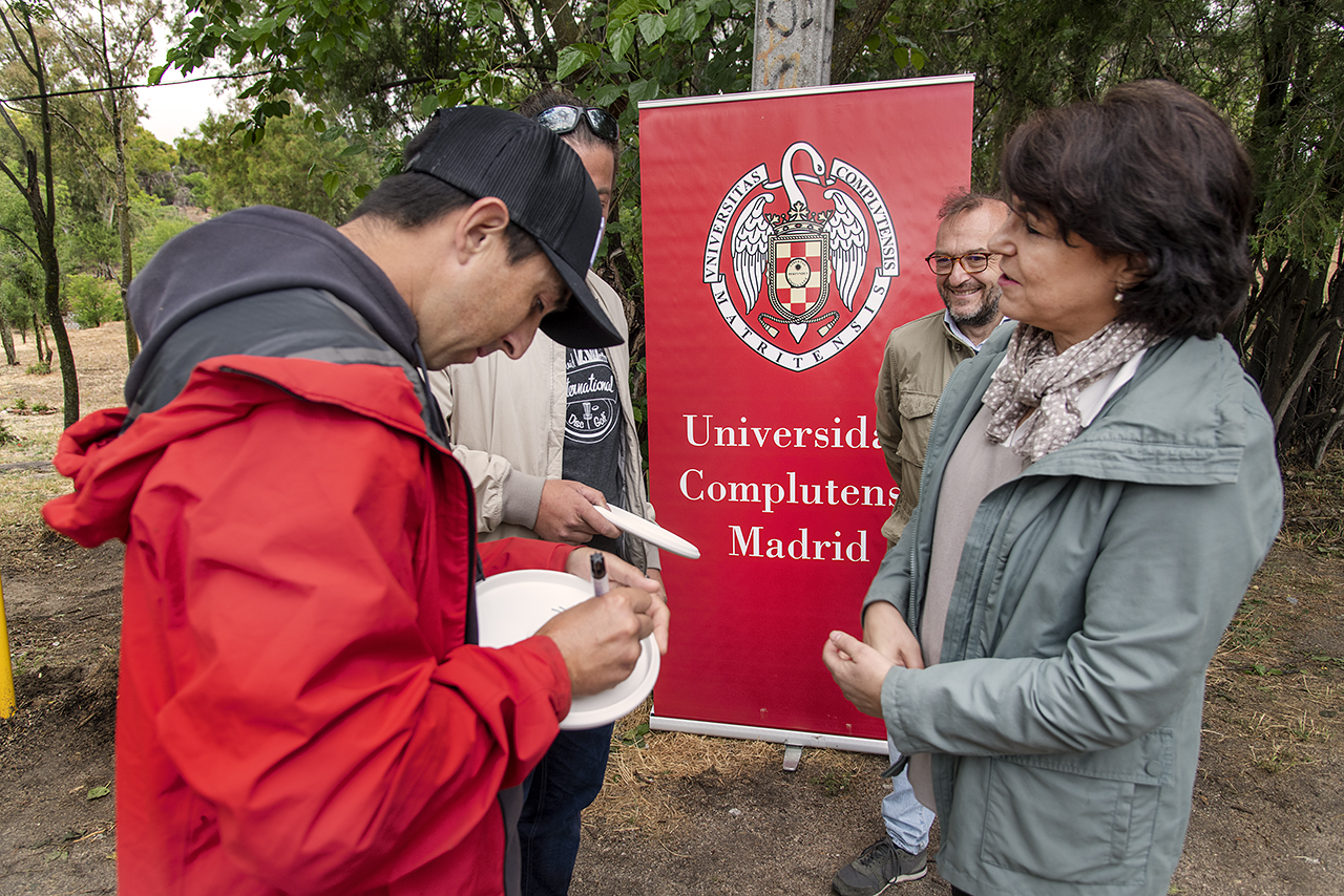 Paul McBeth firma un frisbee como recuerdo de la apertura del campo, en presencia de la vicerrectora Isabel García