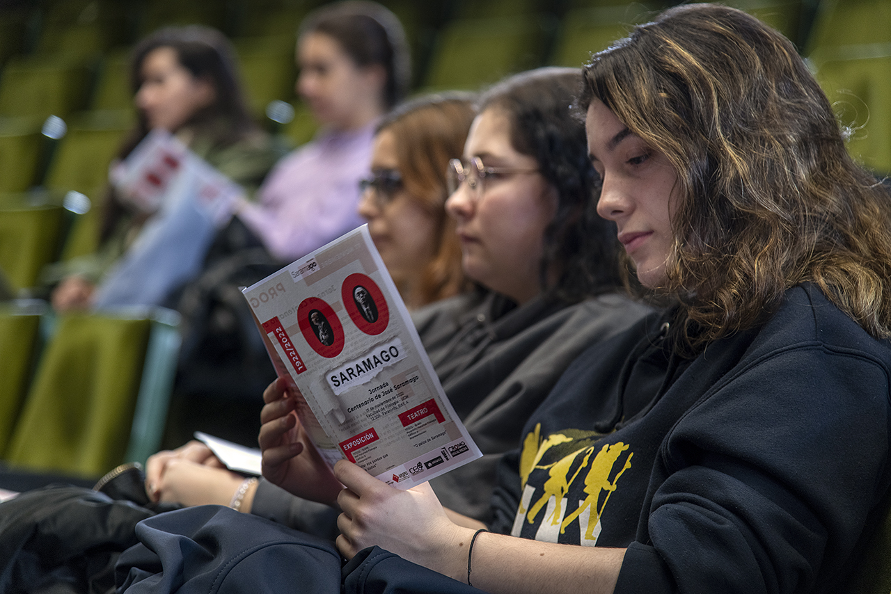 Una asistente a la presentación de la Jornada observa el folleto diseñado por Amable González