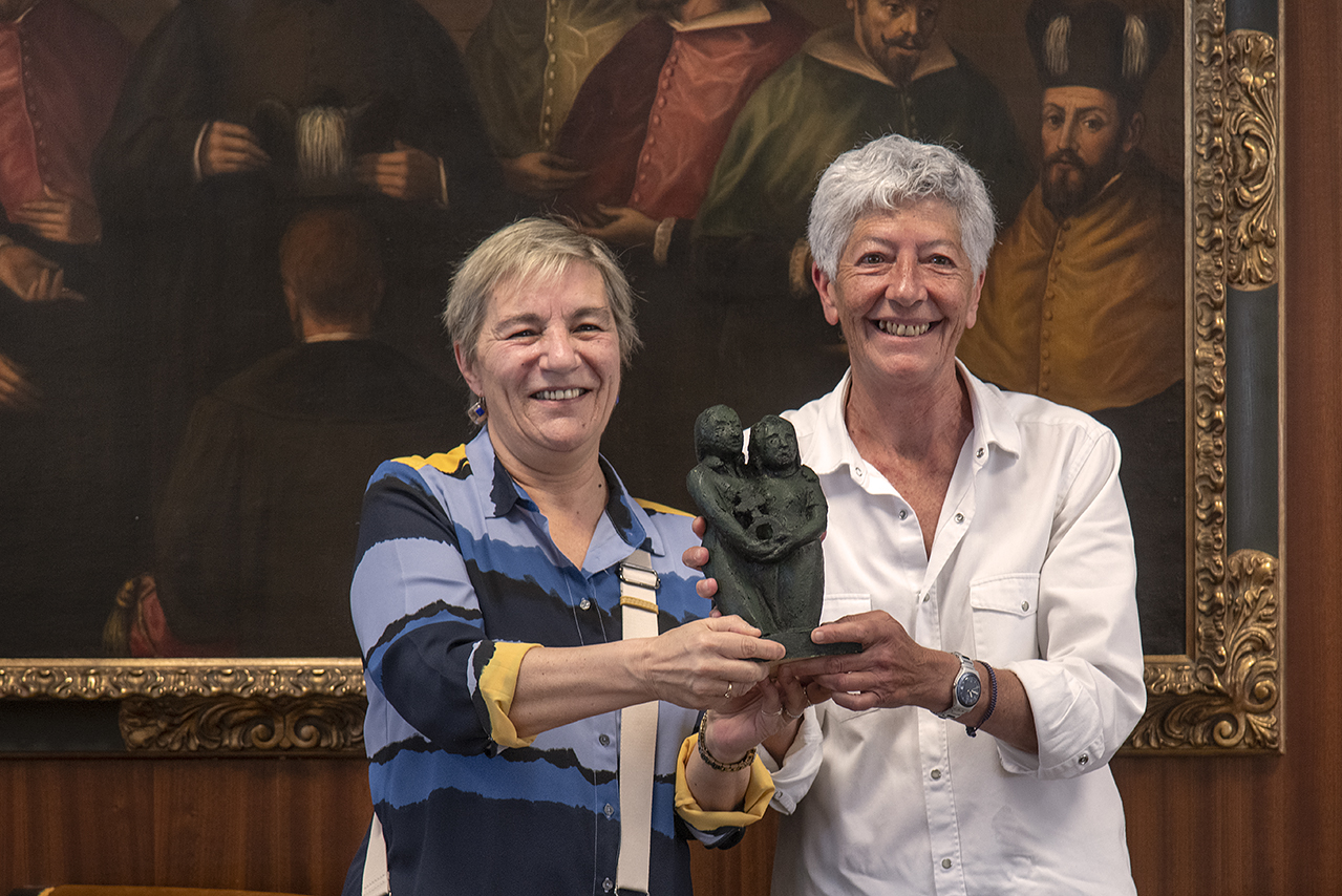 Belén Nogueiras muestra, junto a la directora de su tesis, Luisa Posada, la escultura realizada por Pilar Foronda para simbolizar el premio