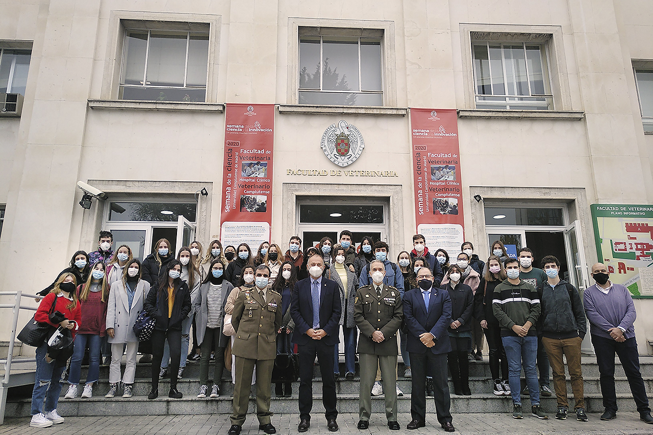 Participantes y asistentes a la jornada posan ante el edificio principal de la Facultad de Veterinaria