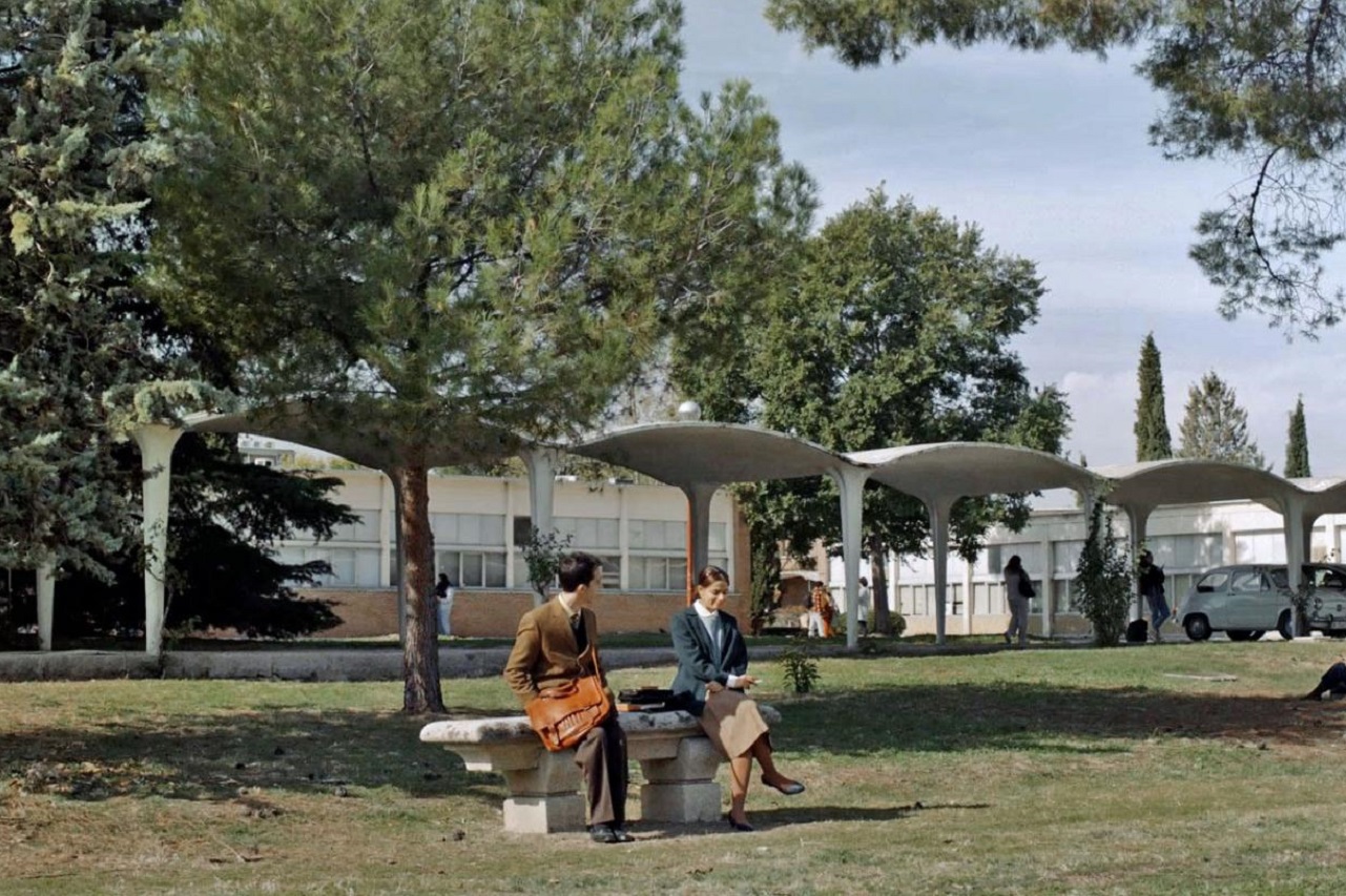 Fotograma de "Arquitectura emocional 1959", con los protagonistas sentados en el "banco de Andrea", de la Facultad de Estadística