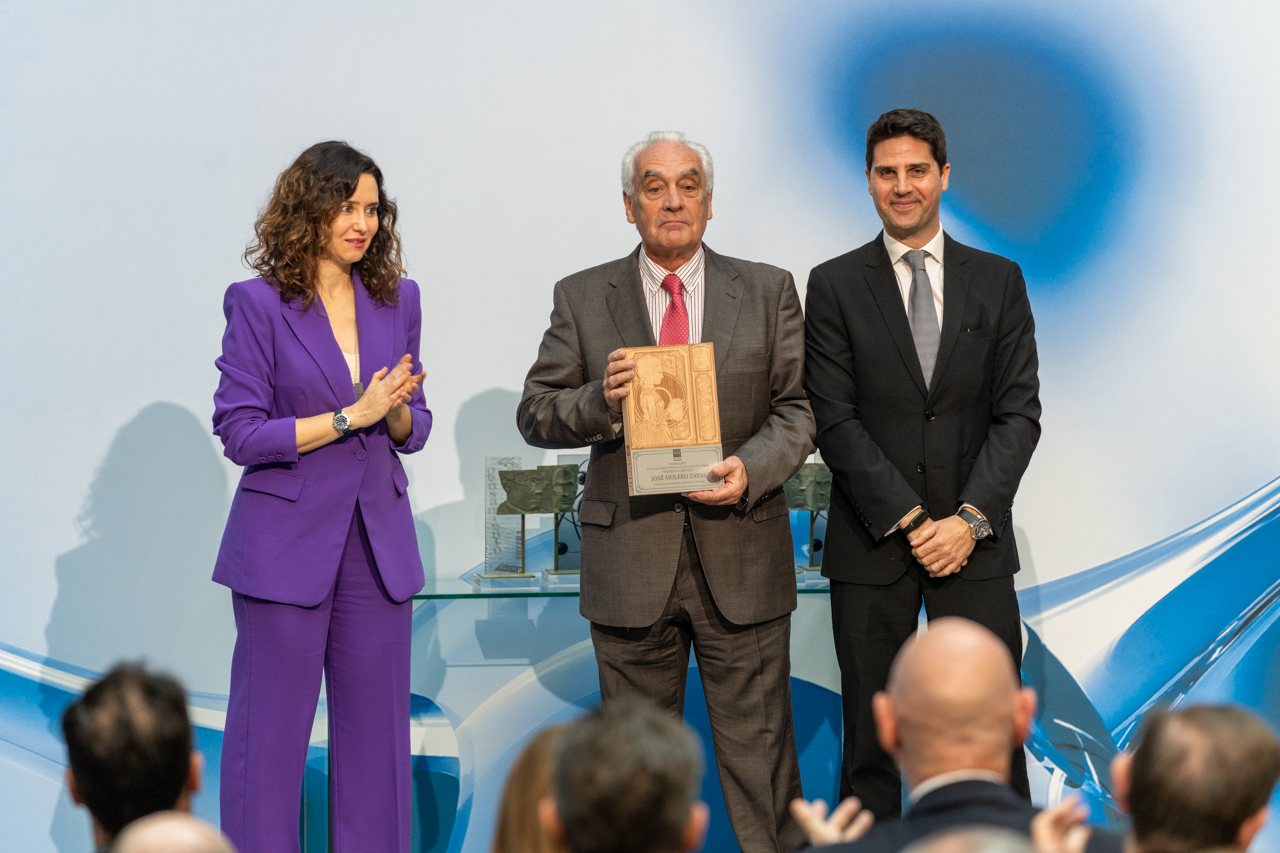 El profesor Molero Zayas muestra el premio, en presencia de Isabel Díaz Ayuso y Emilio Viciana
