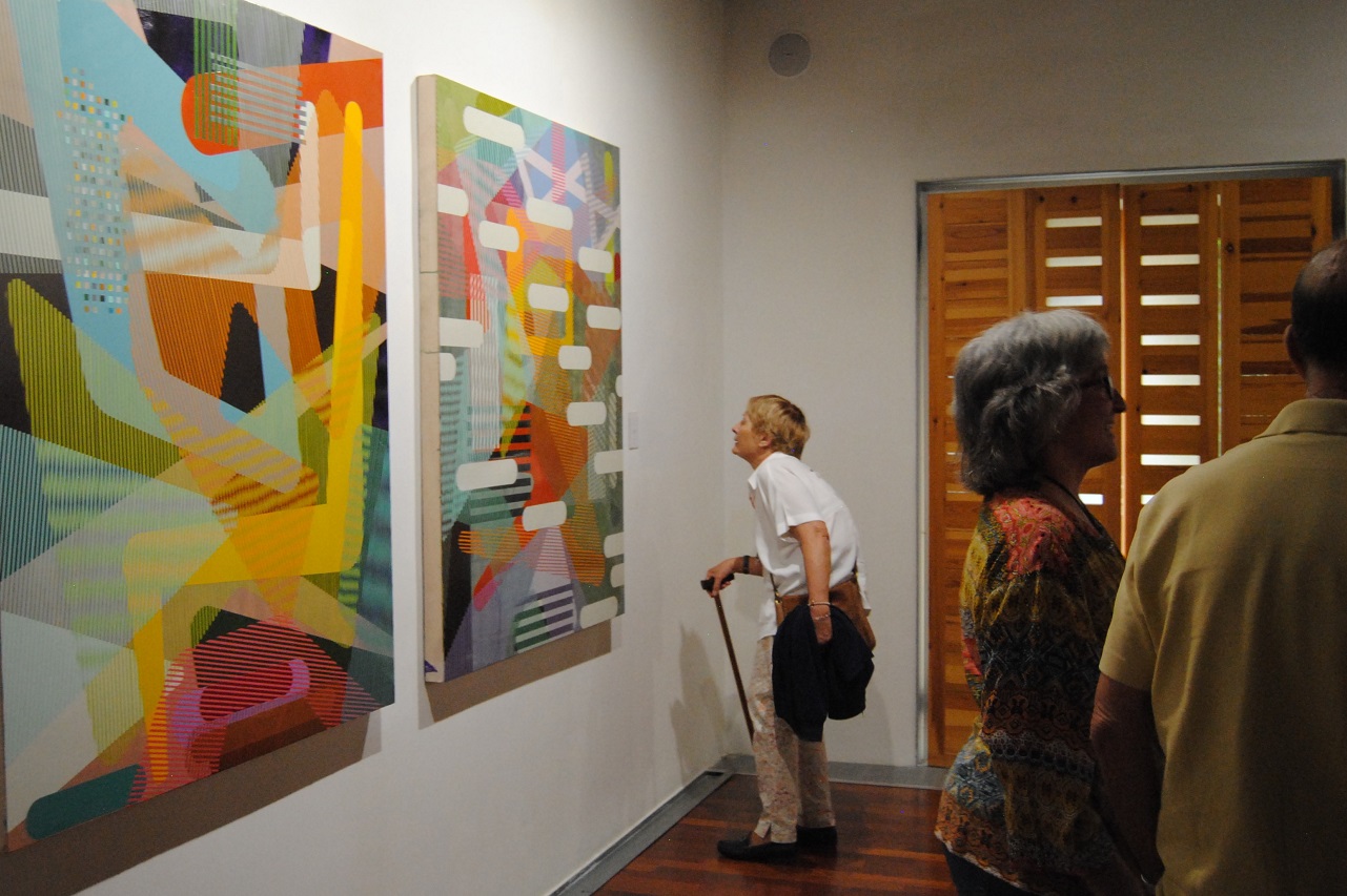 Una visitante entre las pinturas de Alfonso Sicilia Sobrino y una escultura de Guillermo Lledó