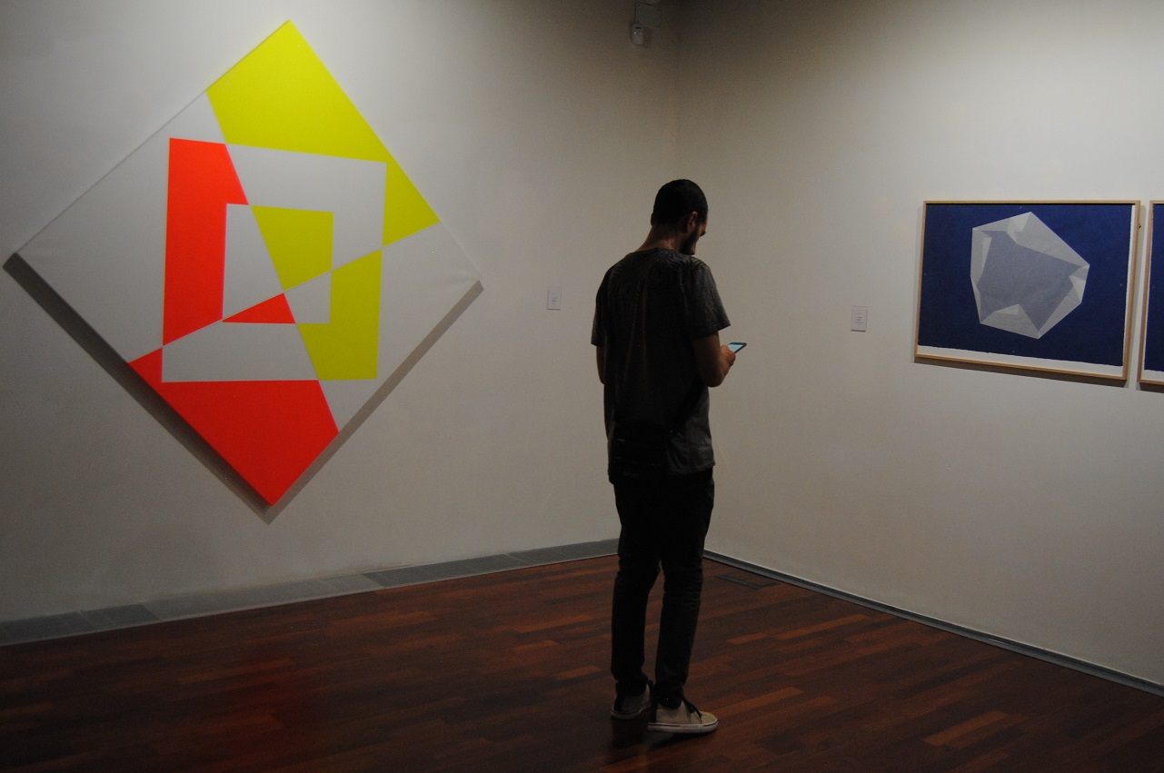 Un visitante entre una pintura de Waldo Balart y dibujos de Anto Rabzas